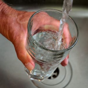 Hand holding glass of water